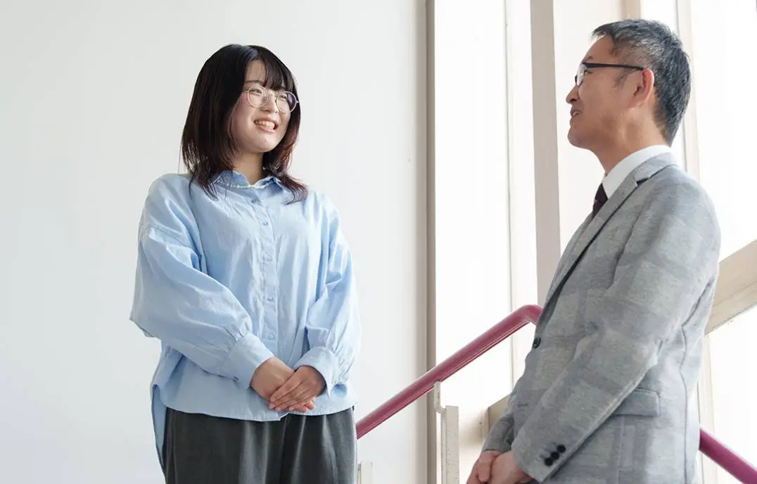 林専任講師と学生の村瀬さんが立って話している様子