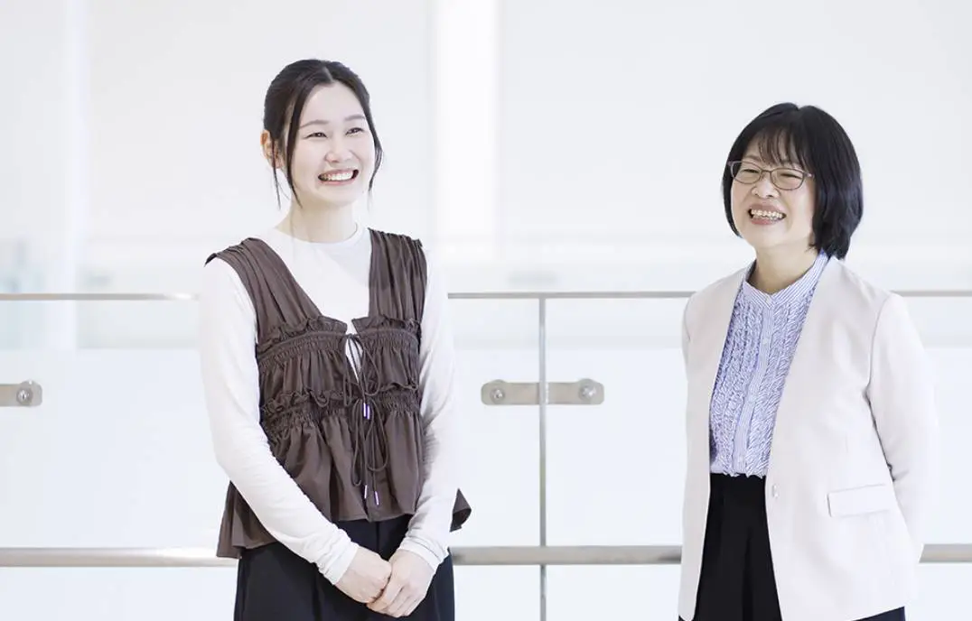 大塚教授と学生の青木さんが立って話している様子